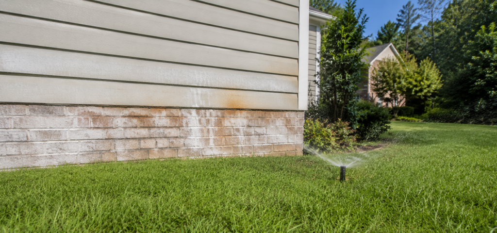Orange rust stains on siding from sprinklers in Raleigh NC